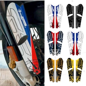 May include: Motorcycle fork guard decals in various designs and colors. The decals feature text such as "HP", "Trophy", "Rallye", and "Exclusive". The designs include red, white, blue, black, and gold accents.