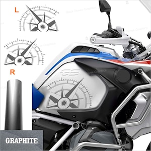 Peut inclure: Un réservoir d'essence de moto gris et blanc avec un graphique de boussole et le texte "GS" sur le côté. Le réservoir est en métal et a un bouchon en plastique noir.