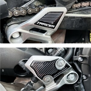 Op de afbeelding: Close-up van een motorfiets met twee zwarte carbon fiber bescherm stickers. De stickers zitten op het frame van de motorfiets en hebben de tekst "TRACER" en "BLACK DOVES GRAPHICS" erop gedrukt.