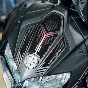 Può includere: Primo piano di un cupolino per moto grigio opaco. Presenta dettagli neri e in stile fibra di carbonio con finiture rosse. Il testo "Black Doves Graphics" e "Moto Styling Team" è visibile.