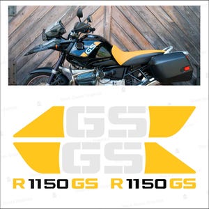 Puede incluir: Un conjunto de calcomanías de vinilo amarillas y blancas con el texto GS y R 1150 GS. El diseño incluye dos grandes formas de flecha amarillas que flanquean las letras GS, con el nombre del modelo R 1150 GS impreso en negro y amarillo debajo.