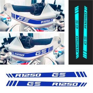 May include: Two sets of blue and white motorcycle decals with the text "R1250 GS" on a white background. The decals are shown on a motorcycle handlebar and as individual stickers.