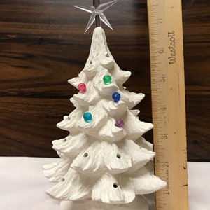 May include: White ceramic Christmas tree with a star on top and colorful light bulbs. The tree is 7 inches tall and has 15 light bulb holes.