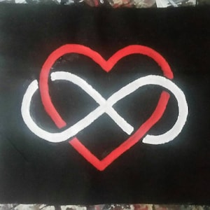 Könnte beinhalten: Schwarzes rechteckiges Kunstwerk mit einem roten Herz, das mit einem weißen Unendlichkeitssymbol verschlungen ist. Das Design ist auf einem schwarzen Hintergrund gemalt. Das Kunstwerk ist wahrscheinlich ein Symbol für Liebe und Ewigkeit.
