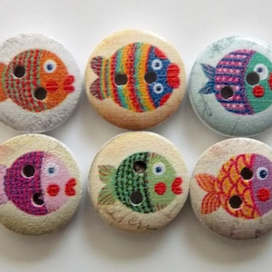 Può includere: Sei bottoni rotondi in legno con disegni di pesci colorati. Ogni bottone presenta un pesce diverso con vari motivi e colori, tra cui arancione, blu, verde e rosa. I bottoni hanno due fori per cucire.
