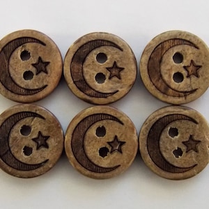 May include: Six wooden buttons with a crescent moon and star design. The buttons are brown with a light brown wood grain pattern. Each button has two holes for sewing.