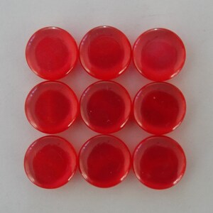 Peut inclure: Neuf pions de jeu en plastique rouge en forme de cercles. Les pions sont disposés en grille de 3x3.