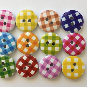 Peut inclure: Douze boutons en bois ronds avec un motif vichy dans différentes couleurs, notamment rose, jaune, orange, bleu, vert, rouge et violet.