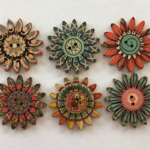 May include: Six wooden flower-shaped buttons with intricate mandala designs in shades of orange, green, blue, and brown. The buttons have two holes each.