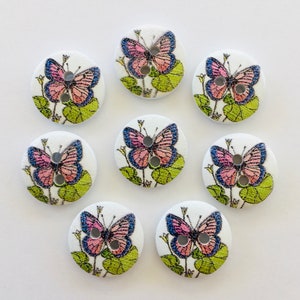 Peut inclure: Ensemble de huit boutons ronds en bois blanc avec un motif de papillon rose et bleu. Chaque bouton a deux trous.