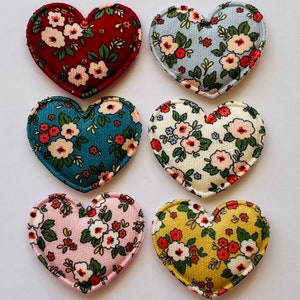 May include: Six fabric heart-shaped patches with floral patterns in red, blue, teal, cream, pink, and yellow.