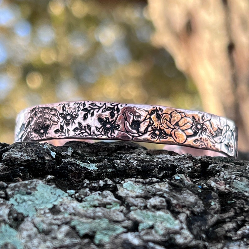 shiny copper cuff bracelet engraved all over with bees, honeycombs, flowers and leaves