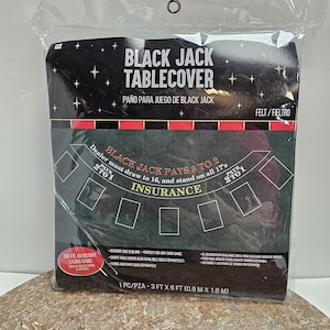 May include: Black Jack Tablecover in a plastic package. The black felt table cover has a printed design with the text "Black Jack Pays 3 to 2" and "Insurance". The dimensions are 0.9 m x 1.8 m.