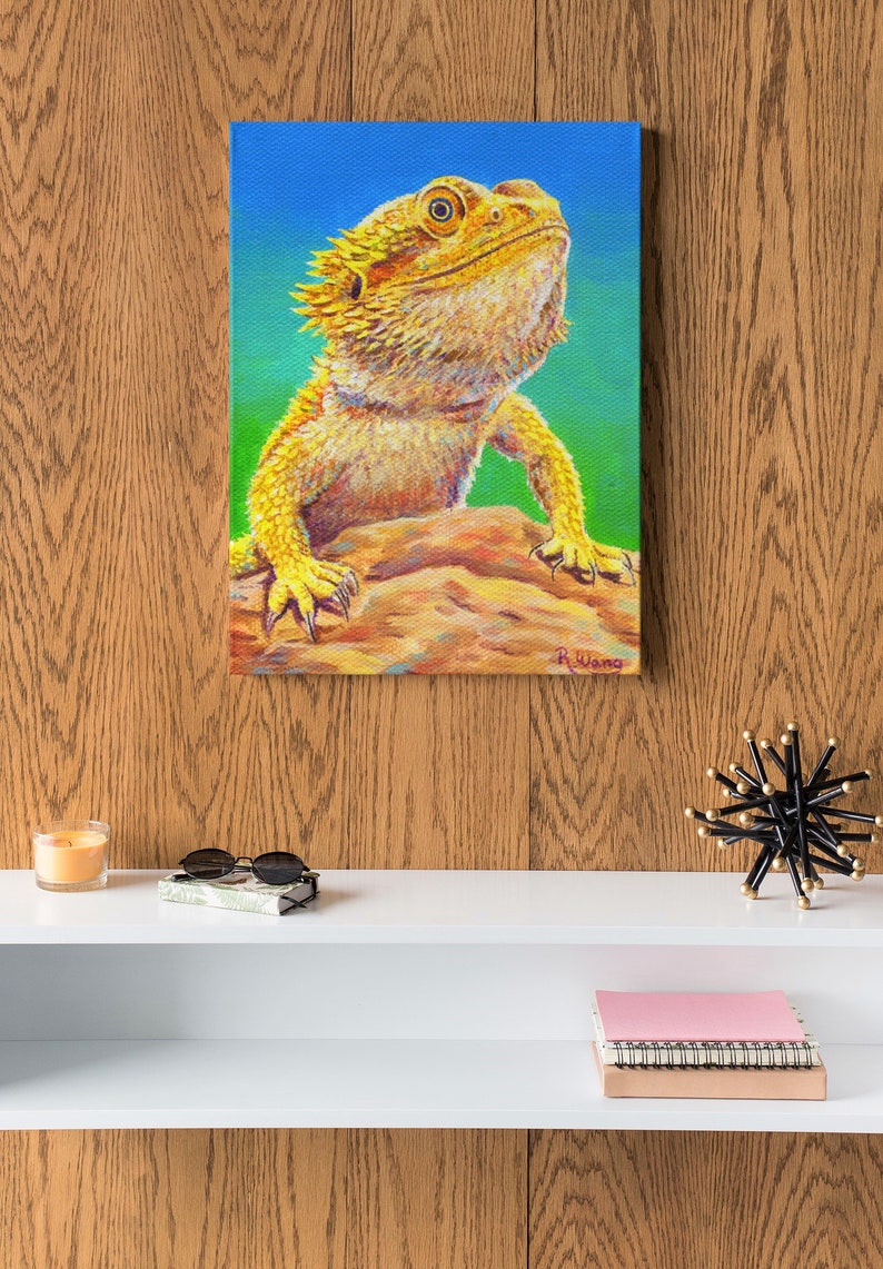 Canvas art print wall art portrait of a yellow bearded dragon lizard with a bright green and blue background.