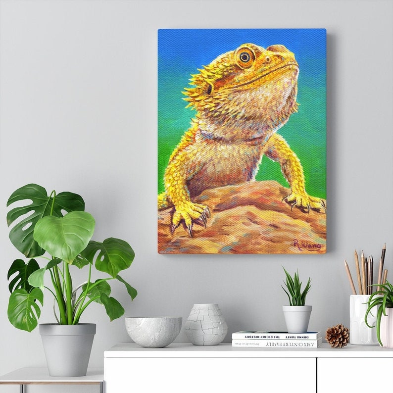 Canvas art print wall art portrait of a yellow bearded dragon lizard with a bright green and blue background.