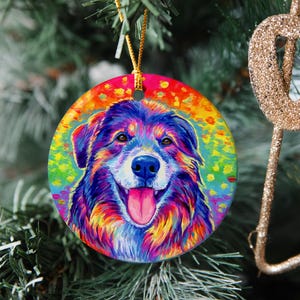 May include: A colorful, abstract painting of a dog's head with rainbow colors on a round ornament. The dog has brown, black, and white fur with a pink tongue sticking out.