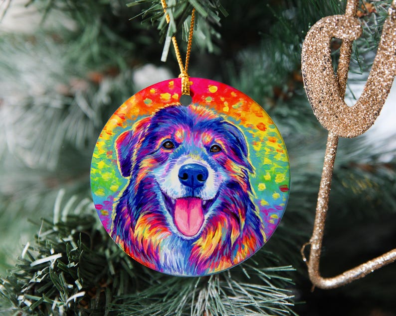 May include: A colorful, abstract painting of a dog's head with rainbow colors on a round ornament. The dog has brown, black, and white fur with a pink tongue sticking out.