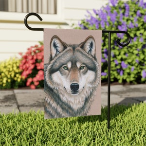 May include: A close-up of a wolf's face. The wolf has brown and gray fur, green eyes, and a black nose. The wolf is looking directly at the viewer.