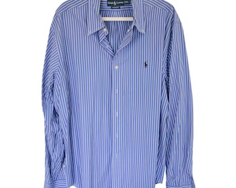 May include: Blue and white striped button-down shirt. The long-sleeved shirt has a classic collar and a small embroidered logo on the chest. The shirt is hanging on a white hanger.