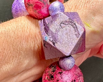 Pulsera jaspeada de abalorios grandes gruesos, cerámica, madera, elástico violeta rosa metalizado.