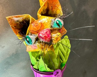 Gato en cubo, tapón de corcho/botella de vino, papel maché hecho a mano, 11,5'', gato manchado de amarillo y naranja, cubo morado y hojas verdes.