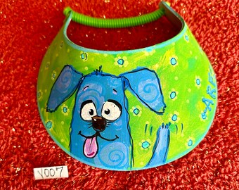Visera para perros, Pintada a mano, Ooak, Perro azul sobre visera verde con pequeñas flores blancas y azules.