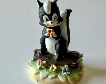Vintage Porcelain SKUNK Figurine Hand Painted Matte Finish Holding Flower on Log