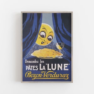 以下が含まれることがあります： 「P&acirc;tes La Lune」Bozon-Verduraz パスタのヴィンテージ広告。広告には顔のある漫画の月、パスタの皿、ワイングラスが描かれています。テキストには「Demandez les P&acirc;tes La Lune Bozon-Verduraz」と書いてあります。