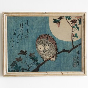 May include: A framed print of a Japanese woodblock print depicting an owl perched on a branch with a full moon in the background. The print is in shades of blue, brown, and white. The Japanese text in the print reads "Fukuro no zu".