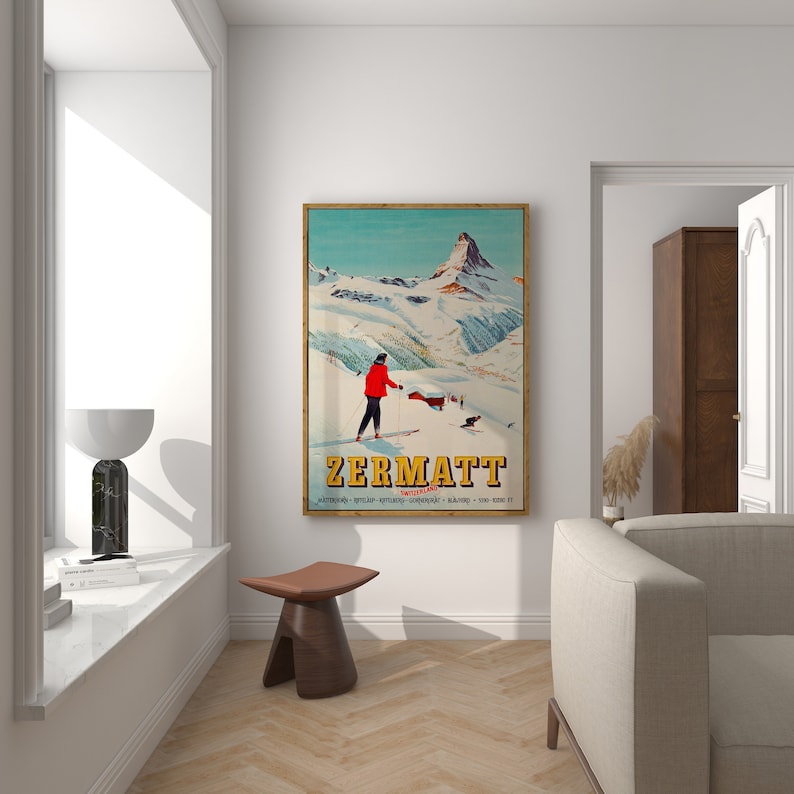 Puede incluir: Un cartel de viaje vintage para Zermatt, Suiza, con un esquiador con ropa roja sobre un fondo de monta&ntilde;a nevado. El cartel tiene un esquema de color azul, verde y blanco e incluye el texto "Zermatt, Suiza".