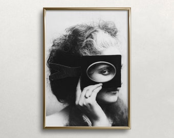 Könnte beinhalten: Ein Schwarzweißfoto einer Frau mit lockigem Haar, die eine Lupe vor ihr Auge hält.