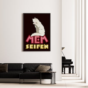 May include: A framed poster featuring a white cat grooming itself. The poster has a dark background with the words "MEM SEIFEN" in red and yellow stylized text. The poster is hanging on a white wall above a black leather sofa.