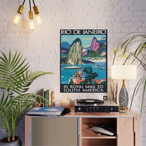 May include: Vintage travel poster advertising a trip to Rio de Janeiro, Brazil by Royal Mail to South America. The poster features a colorful illustration of Sugarloaf Mountain and Guanabara Bay.