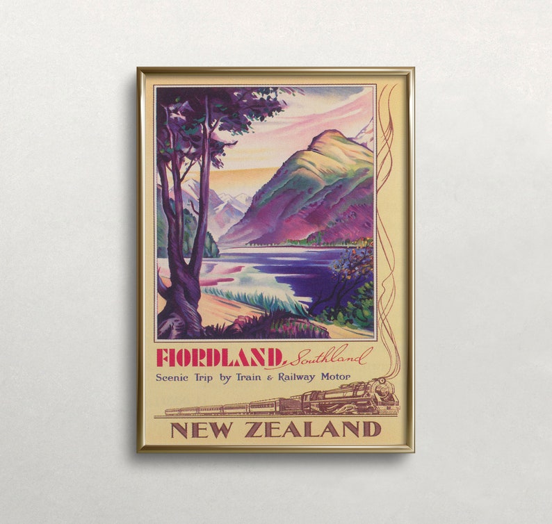 Puede incluir: P&oacute;ster de viaje vintage enmarcado para Fiordland, Southland, Nueva Zelanda. La obra de arte representa un paisaje esc&eacute;nico con monta&ntilde;as, un lago y un tren. El p&oacute;ster tiene un marco dorado y presenta el texto "Fiordland, Southland" y "New Zealand."