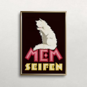 May include: Framed vintage advertisement featuring a white cat grooming itself. The cat sits atop the word "MEM" in pink, with "SEIFEN" in yellow below. The background is dark brown, and the frame is gold.