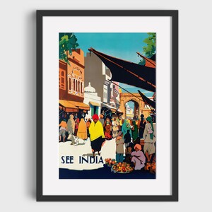 May include: A framed vintage travel poster with the text "SEE INDIA." The artwork depicts a bustling street scene with people in traditional clothing, buildings, and a market. The color palette includes blues, oranges, yellows, and greens, creating a vibrant and inviting image.
