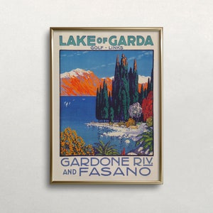 May include: A framed vintage travel poster for Lake Garda, Italy, featuring a scenic view of the lake and mountains. The poster has text that reads "Lake of Garda Golf Links" and "Gardone Riv. and Fasano". The artwork uses a vibrant color palette of blues, oranges, and greens.