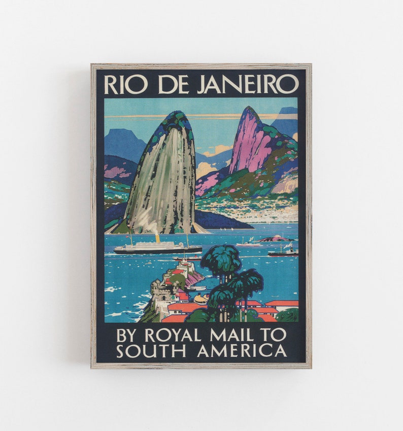 May include: Vintage travel poster advertising a trip to Rio de Janeiro by Royal Mail to South America. The poster features a colorful illustration of Sugarloaf Mountain and Guanabara Bay with a ship in the water.