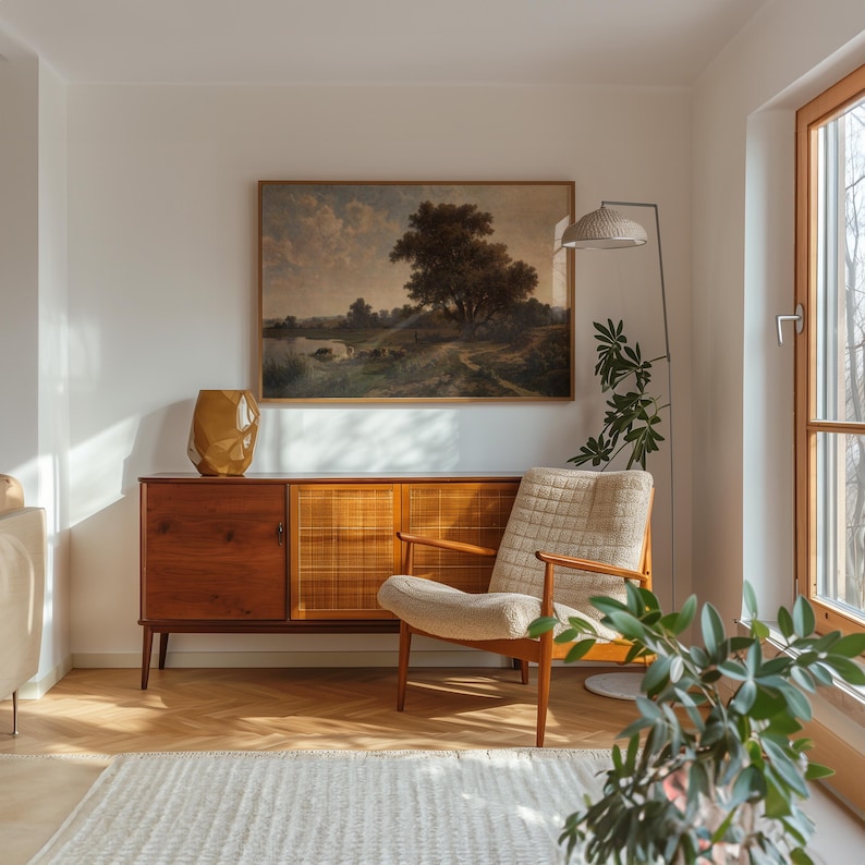 K&ouml;nnte beinhalten: Ein Wohnzimmer im Stil der Mid-Century Modern mit einem Holzschr&auml;nk, einem wei&szlig;en Sessel, einer Stehlampe und einem gerahmten Landschaftsbild an der Wand.