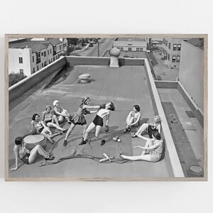 Puede incluir: Impresi&oacute;n enmarcada en blanco y negro de mujeres en una azotea. Varias mujeres est&aacute;n boxeando, mientras que otras est&aacute;n sentadas o tumbadas. La escena incluye guantes de boxeo, mazas de malabarismo y una pelota.