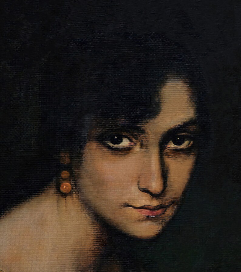 Pode incluir: Um retrato de perto de uma mulher com cabelo escuro e olhos castanhos. Ela est&aacute; usando um par de pequenos brincos redondos laranja. O fundo &eacute; escuro.