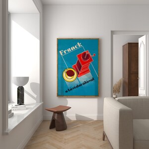 May include: A vintage poster with a blue background and a red coffee grinder with a yellow cup of coffee. The poster reads "Franck a k&aacute;v&eacute;dar&aacute;l&oacute;val" in black text.