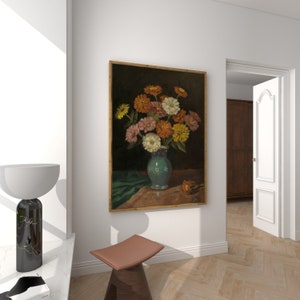 May include: A painting of a bouquet of pink, yellow, and white flowers in a blue vase on a table with a green cloth. The flowers are arranged in a vase with a white and blue pattern. The painting is framed in a gold frame.