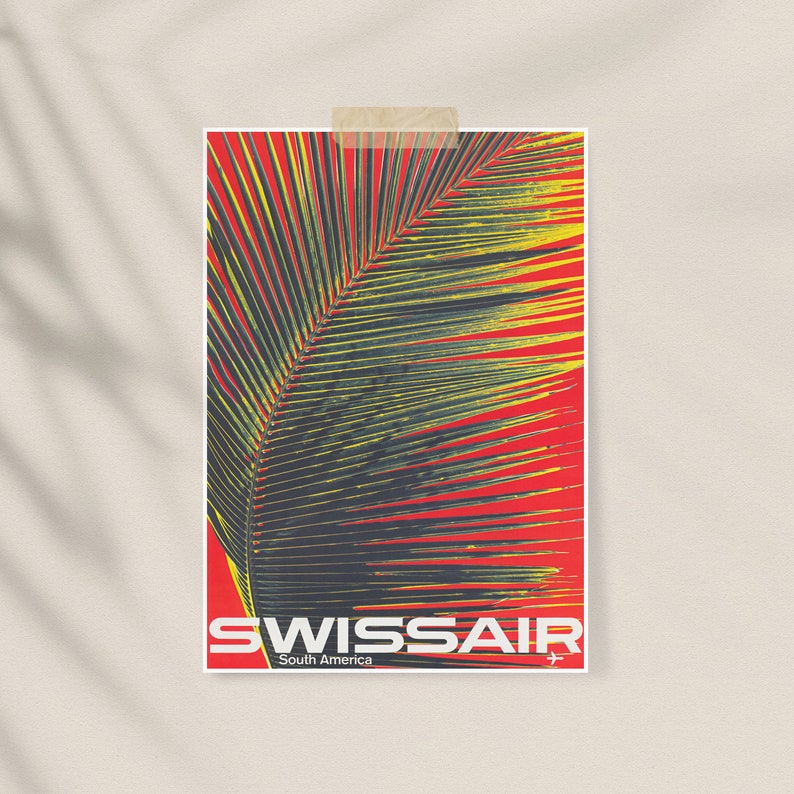 May include: A poster featuring a stylized palm leaf against a red background. The poster has the text "SWISSAIR South America" in white. The poster is attached to a neutral wall with a piece of tape.