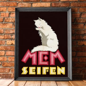 May include: Framed vintage poster featuring a white cat grooming itself. The cat is set against a dark background, with the words "MEM SEIFEN" in pink and yellow stylized lettering. The poster is in a black frame.
