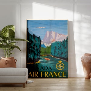 May include: A vintage travel poster for Air France featuring a mountain landscape with a plane flying overhead. The poster is in shades of blue, green, and brown with the text "Canada Air France" in gold lettering.