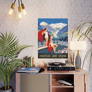 May include: Vintage travel poster advertising Chateau Lake Louise in the Canadian Rockies. The poster features a blue and green mountain landscape with a lake and two women in bathing suits standing on a diving board.