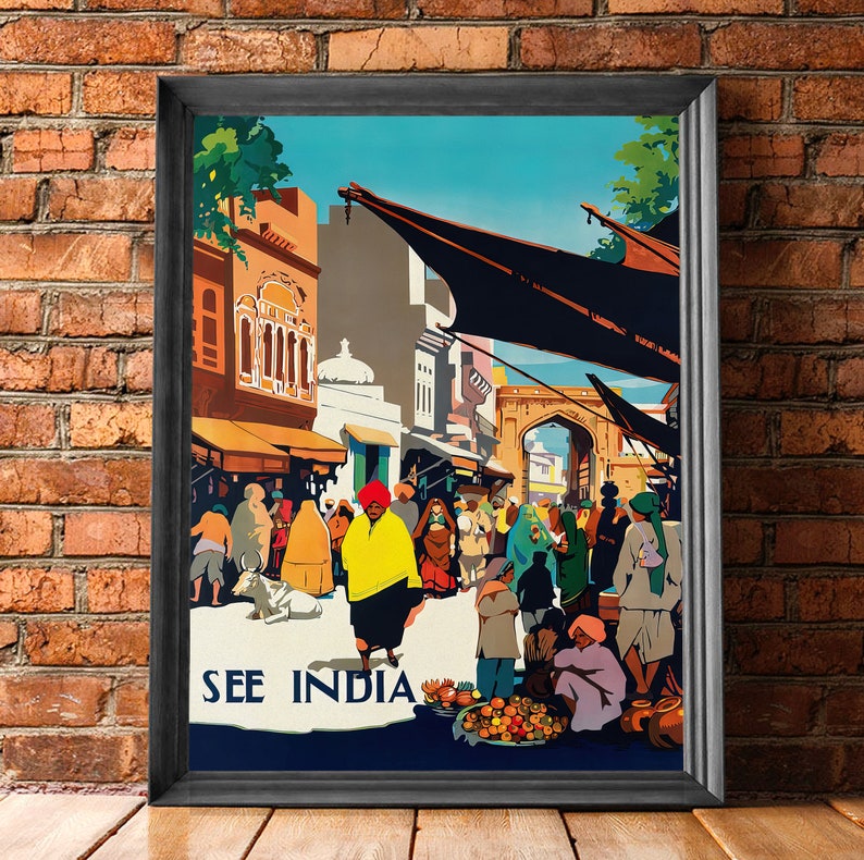 May include: Framed vintage travel poster with the text "SEE INDIA." The artwork depicts a bustling marketplace scene with people in traditional clothing, buildings, and market stalls. The color palette includes shades of orange, yellow, blue, and black.