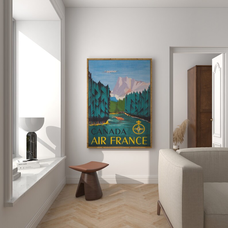 May include: Vintage travel poster featuring a scenic landscape with mountains, trees, and a river. The poster is in a wooden frame and has the text "CANADA AIR FRANCE" at the bottom.