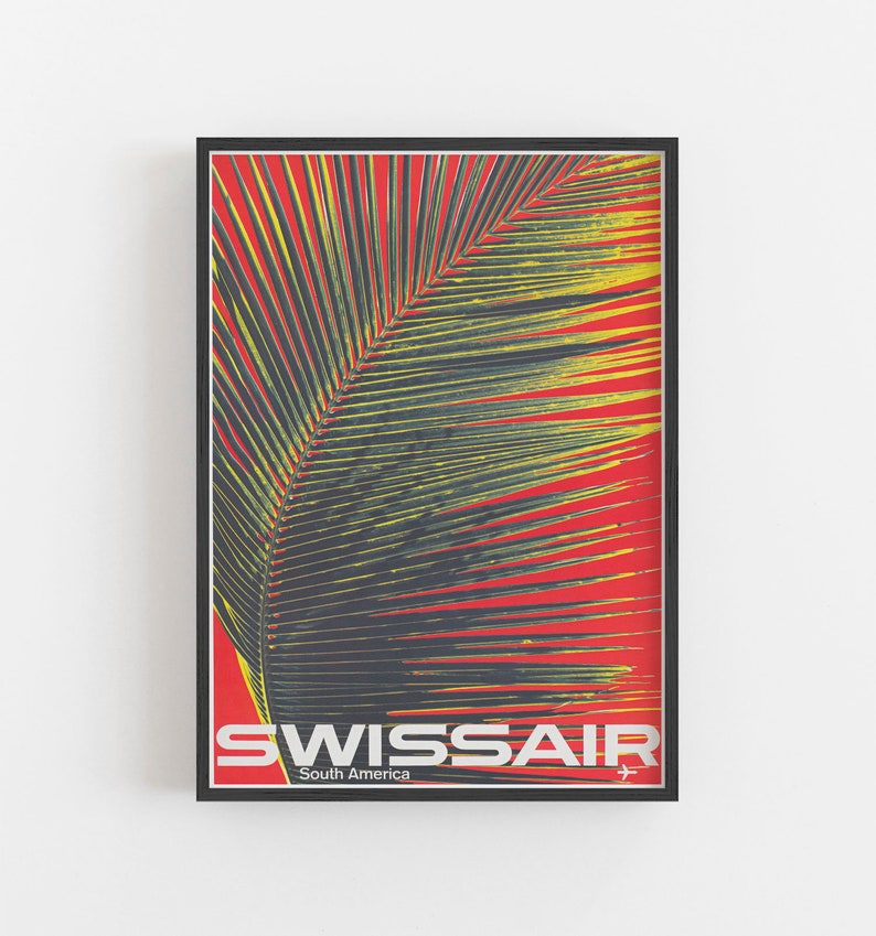 May include: A framed vintage travel poster for Swissair, featuring a palm leaf against a red background. The poster has the text "SWISSAIR South America" in white and silver, with a small airplane graphic.